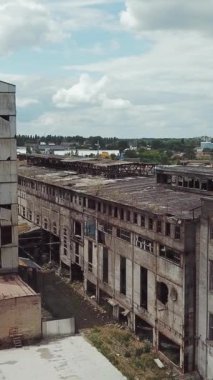 Yok edilen fabrikanın üzerinden uçacağız. Yıkım için eski endüstriyel bina. Hava görüntüsü. Dikey video