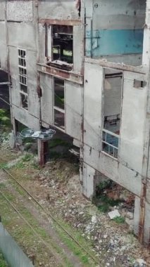 Terk edilmiş bir sanayi bölgesinin insansız hava aracı görüntüsü. Fabrika harabeleri, dikey video.
