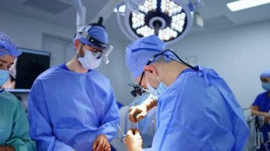 Nörocerrahi iki cerrah ve ameliyat hemşiresi tarafından gerçekleştirildi. Cerrahi hoparlörlerdeki doktorlar çeşitli aletler kullanırlar..