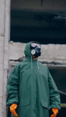 Çevre kirliliği, ekolojik felaket, nükleer savaş, kıyamet sonrası konsepti. Gelecek nesilleri düşün. Koruyucu maskeli insan, zehirli hava solumasını önlemek için yüz koruması. Dikey video