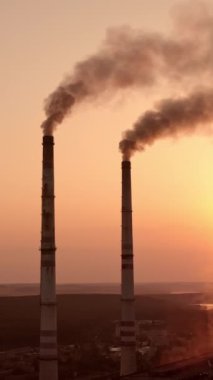 Gün batımı arkaplanındaki güç direklerinin statik görüntüsü. Gün batımında yüksek voltajlı elektrik kulesi. Kumaş konsepti. Seçici odaklanma. Dikey video