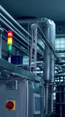 Süt endüstriyel fabrikasının içi. Süt ürünleri üretimi için metal tüplü yeni ekipmanlar. Otomatik ekipmanlı modern süt fabrikası dikey video.