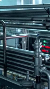 Süt ürünleri fabrikasında metal tüplü endüstriyel ekipmanlar. Süt ürünleri üretim tesisinde endüstriyel boruları olan fabrika makineleri. Üretim süreci... dikey video