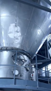 Büyük süt işleme tesisi. Fabrikanın içinde süt ürünleri üretmek için modern metal ekipmanlar var. Süt ürünleri üretim tesisi.