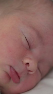 Sevimli bebek evdeki yumuşak yatakta huzur içinde uyuyor. Uyuyan bir çocuğun yüz portresi. Sağlıklı bir rüya. Doğumdan sonra ebeveynler için sessiz bir gece.
