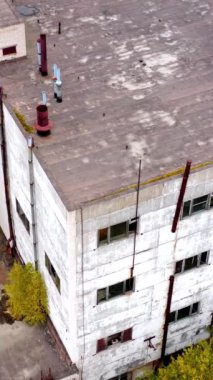 Eski fabrika. Terk edilmiş binalar ve savaştan sonra camları kırılan depolar. Boş sanayi fabrikası. Yukarıdan görüntüle... dikey video