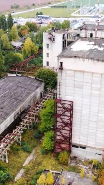Dünya krizinin sebep olduğu boş fabrika. Sanayi tesisinin terk edilmiş binaları. Eski tuğla binalar ve depolar. Kamera yükseliyor... dikey video