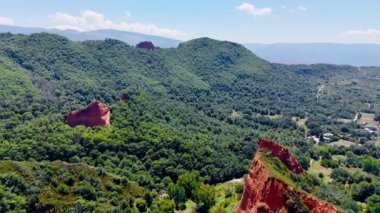 Bereketli, sık ormanlar kayaları kaplıyor. Güneşli bir günde, dağların tepesindeki drone görüntüleri..