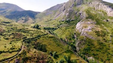 Yeşil çimenler ve çalılarla kaplı devasa dağlar. İspanya, Avrupa 'daki muhteşem kayaların muhteşem manzarası. Hava görünümü.