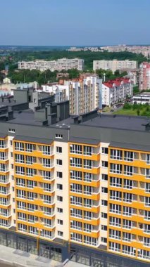 Şehir manzarası arasında çağdaş apartman blokları. Yeni tasarımın modern çok katlı binası. Şehirde yeni bir dönüm noktası. Yukarıdan bak. Dikey video