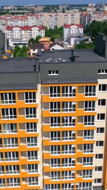 Yeni şehir simgesi. Kentsel arka planda modern bir apartman. Çok katlı bir mimarinin renkli tasarımı. Hava görüntüsü. Dikey video