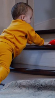 Güzel bebek içeride merdivenlerde oynuyor. Şirin çocuk yüzüğü oyuncak piramitten fırlatıp geri almaya gitti. Dikey video