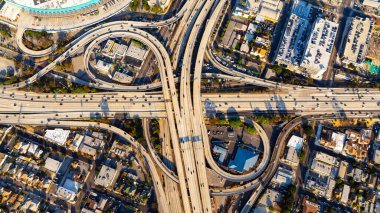 Gün batımında kavşakta otobanlardan ve otobanlardan geçen bir araç. Los Angeles 'taki trafiğin en üst görüntüsü.