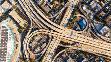 Lively traffic on the highways, loops and freeways in Los Angeles downtown. Approaching famous interchange in metropolis midtown. clipart