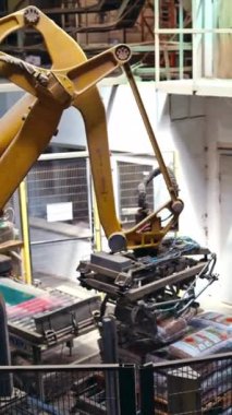 Yapay zekaya sahip mekanik robot taşıyıcıdaki çantaları ayırıyor. Çantaları halattan palete yerleştiriyorum. İşlem yakın çekim. Dikey video