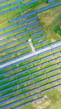 Yazın ekolojik enerji santrali. Sahadaki güneş panellerinin üst görüntüsü. Yenilenebilir enerji. Alternatif elektrik kaynağı. Hava görüntüsü. Kamera hareket ediyor. Dikey video