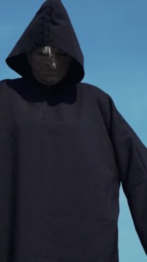 Ürkütücü cadı kamerayı izliyor. Cadılar Bayramı kostümü dikey video.