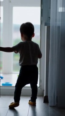 Küçük bebek balkon kapısına koşar ve kapıyı kapatır. Sonra tekrar açılır ve mutlu bir şekilde balkona doğru yürür. Dikey video