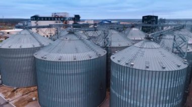 Tahıl deposu için devasa metal silo tankları yığını. Zirai asansörlerin tepesindeki İHA görüntüleri..