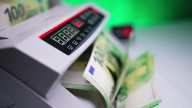 Döner bıçaklı para sayma makinesi. El, banknotları hareket ettirir ve cihaz hemen nakit sayar. Kapatın. Bulanık arkaplan.