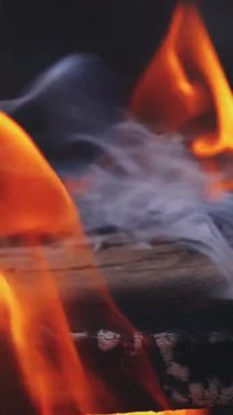 Ev şöminesinde yavaş çekim yanan ateş. Dikey videoyu kapat