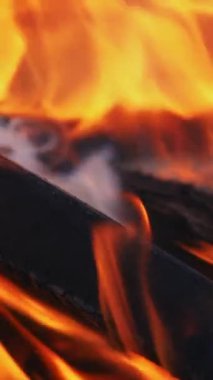 Ateş gecenin karanlığında yanıyor. Şenlik ateşi. Yavaş çekim Dikey video