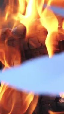 Dalların kamp ateşi Ormanda Gece Yanar. Turuncu bir alevle kaplanmış yanan kağıt. Yangının arka planı. Dikey video