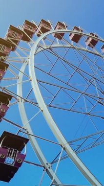 Mavi gökyüzünde büyük bir dönme dolap. Dikey video