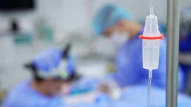 Ameliyathanede damar içi damlalar. Kapatın. Bulanık zeminde iki doktor çalışıyor..