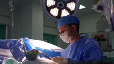 Cerrah operasyonda metal aletler kullanıyor. Ameliyat yapan profesyonel bir doktorun portresi..