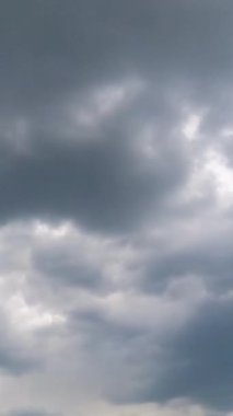 Şiddetli yağmur bulutları gökyüzünde hareket ediyor. Ufku kaplayan gri bulutlar. Zaman ayarlı. Düşük açı. Dikey video