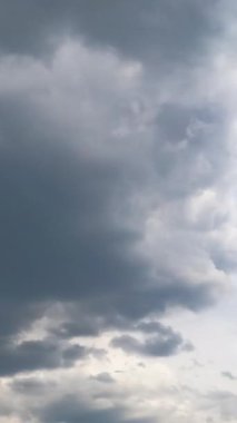 Fırtınalı gri bulutlar atmosferde birikiyor. Kümülüs bulutlu oluşum düşük açılı görüşten gökyüzünde. Zaman ayarlı. Dikey video