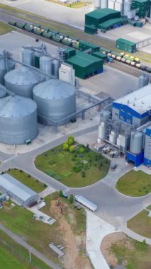 Günışığında modern fabrika. Ürünleri korumak için metal terminallerle tahıl kurutma kompleksi. Yeni tahıl ambarı sahada. Havadan bak. Dikey video