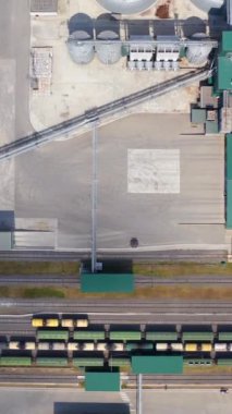 Tahıl depolama ve işleme için bitki. Silo sistem tanklarının üzerinden uçuş. Modern bir tarım fabrikasının metal tahıl kutuları. Hava görüntüsü. Dikey video