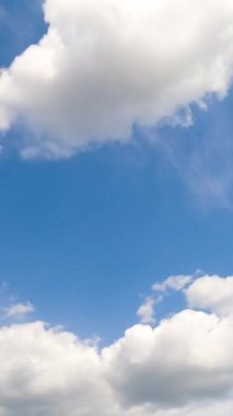 Yumuşak bulutlu açık mavi yaz gökyüzü. Düşük açılı görüşten beyaz bulut oluşumu. Dikey video