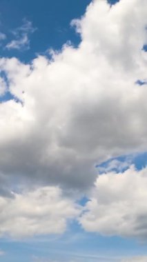 Atmosferde beyaz bulut oluşumu. Yumuşak bulutlu yaz gökyüzü. Düşük açılı zaman dilimi. Dikey video