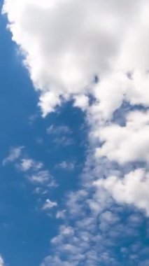 Güzel gök yüzünde hafif, yumuşak bulutlar. Bulutlar atmosferdeki rüzgarla hareket etti. Düşük açılı zaman dilimi. Dikey video