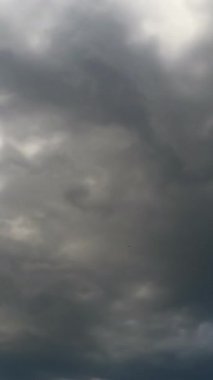 Gökyüzünden yayılan gri yağmurlu bulutlar. Atmosferde yağmur oluşumu. Düşük açılı zaman dilimi. Dikey video