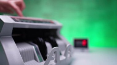 Döner bıçaklarla para sayma makinesinde çalışıyor. Bir yığın 100 dolarlık banknot ekipman olarak sayılıyor. Kapat..