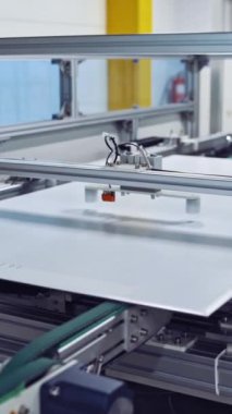 Fabrikanın içinde robot ekipmanları var. Modern endüstriyel santralde yeni detaylar oluşturma süreci. Yakın plan. Dikey video