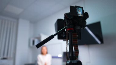 Tripod video bloğundaki modern kamera. Düşük açı. Kadın nüfuzlu kişi bir vlog için içerik oluşturur. Bulanık arkaplan.