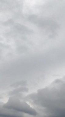 Kötü havalarda gri kasvetli gökyüzü. Gökyüzünü kaplayan yağmur bulutları. Düşük açı. Zaman ayarlı. Dikey video