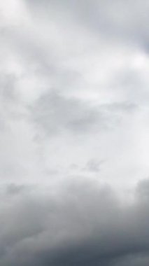 Gri bulutlar hızla gökyüzünde uçar. Horizon yoğun bir şekilde yağmurdan önce bulutlarla kaplıydı. Düşük açı. Zaman ayarlı. Dikey video