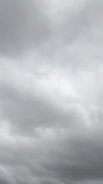Gündüz vakti gökyüzünde yağmurlu bulutlu bir oluşum. Kasvetli hava ufku bulutlarla kaplıydı. Düşük açı. Zaman ayarlı. Dikey video