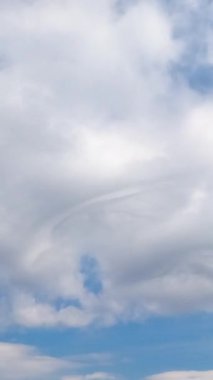 Sirokümülüs bulutları ufku kaplıyor. Gündüz vakti hafif bulutlu yaz gökyüzü. Düşük açı. Zaman ayarlı. Dikey video