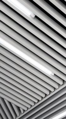 Tavanda beyaz gün ışığı için lambalar bulunan dekorasyon tahtaları. Siyah beyaz görüntü. Düşük açı. Dikey video