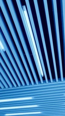 Parlak ışıklandırmalı kabartmalı ahşap tavan. Düşük perspektiften gün ışığına çıkan lambalar. Dikey video