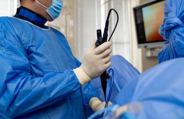 Klinikte endoskopik prosedür. Önlüklü bir sağlık uzmanı gündüz vakti klinik ortamda endoskopik bir işlem gerçekleştirir..
