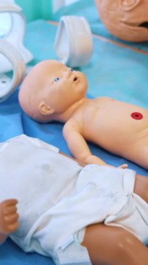 Tıbbi deneyimler için bebek bebekler. Tıp fakültesi öğrencileri için çalışma odasındaki masada duran plastik bebek modelleri. Yakın plan. Dikey video