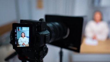 Kadın sunucunun konuşmasını gösteren kamera görüntüsü. Bloglama ve video bloglama konsepti. Kapatın. Bulanık arkaplan.